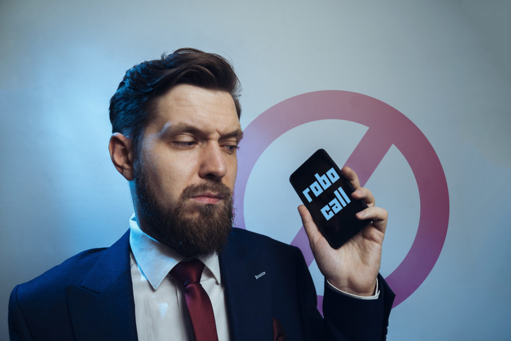 Man frowning receiving telemarketing robo call